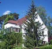 Ein Mehrfamilienhaus von vielen Bäumen umgeben